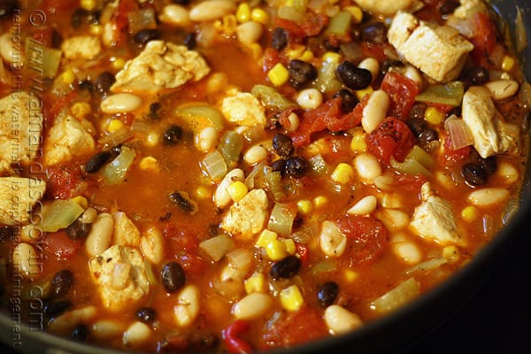 A close up photo of chicken chili with black beans and corn.