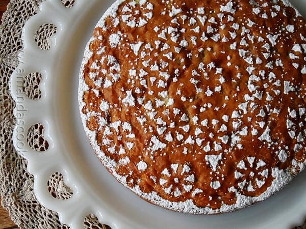 A overhead photo of a Merryfield apple cake on a decorative white platter. 
