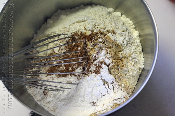 A mixing bowl filled with dry ingredients for pumpkin mini cakes. 