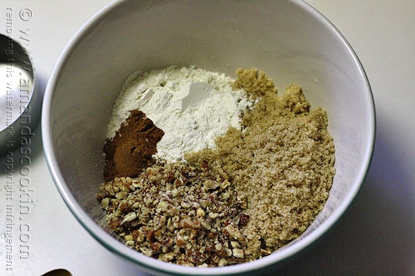 A mixing bowl of chopped pecans, packed brown sugar, unbleached all purpose flour and ground cinnamon.