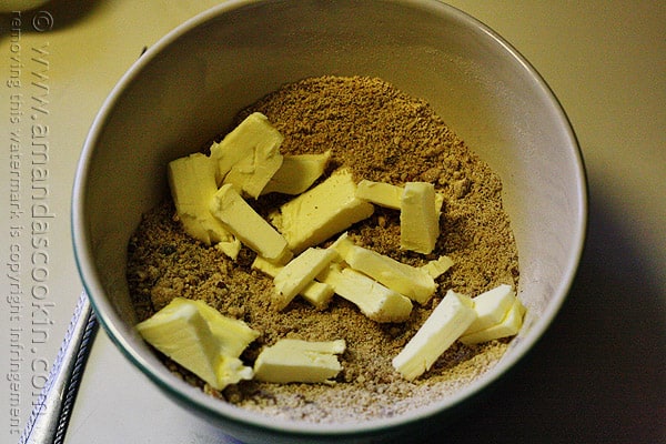A photo of butter squares added to the bowl of streusel topping.