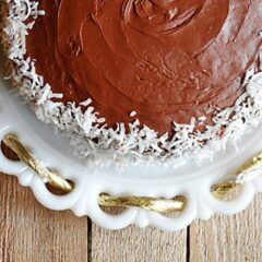 An overhead photo of an almond joy coconut snowflake cake resting on a white cake stand.