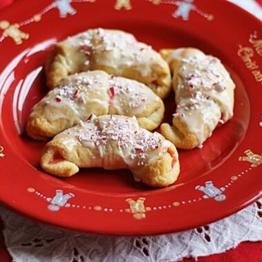 A close up overhead of a white chocolate candy cane crescents on a red plate.