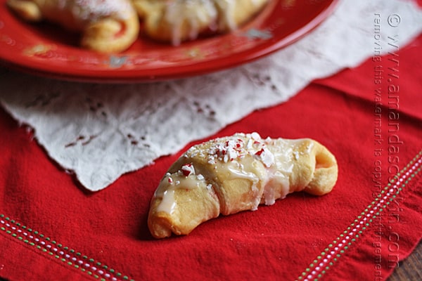 A close up photo of a white chocolate candy cane crescent on a red plate.