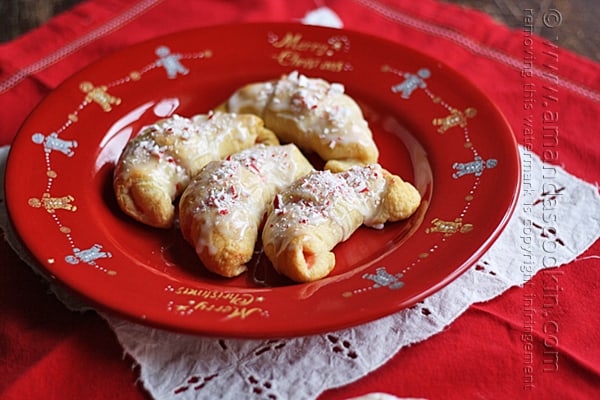 A close up overhead of white chocolate candy cane crescents on a red plate.