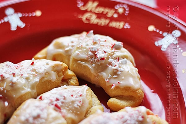 A close up photo of a white chocolate candy cane crescent on a red plate.