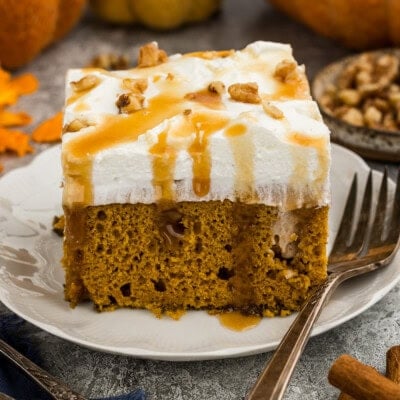 A close up photo of a piece of pumpkin pudding poke cake on a red plate.