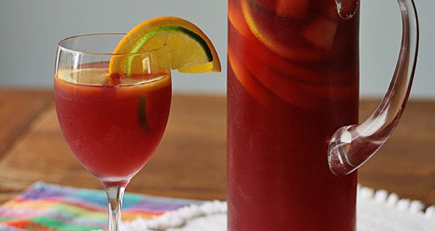 A close up photo of a pitcher and glass filled with Mexican inspired sangria.