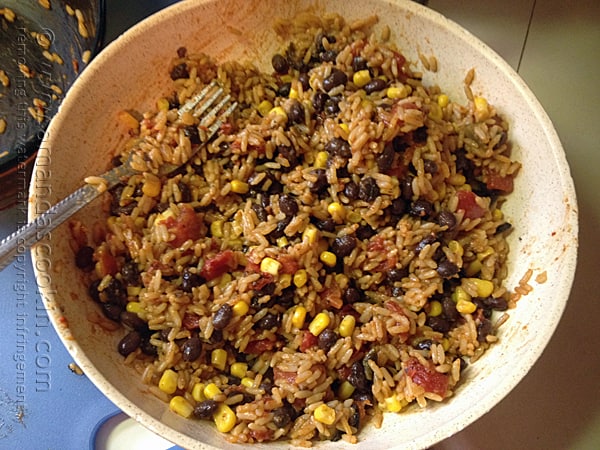 A bowl of Spanish rice with black beans and corn.