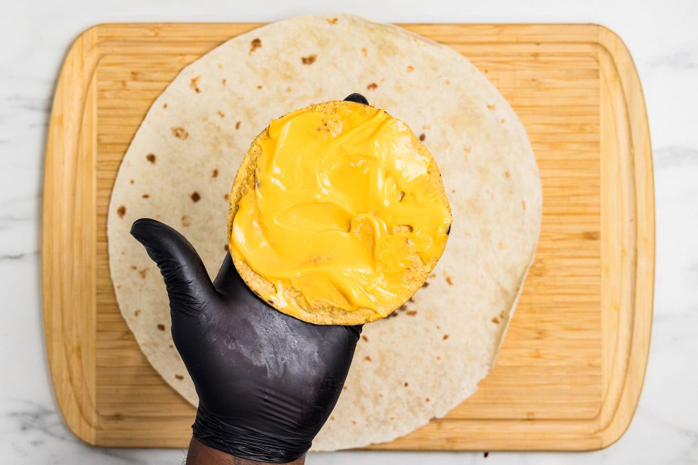 nacho cheese spread onto tostada