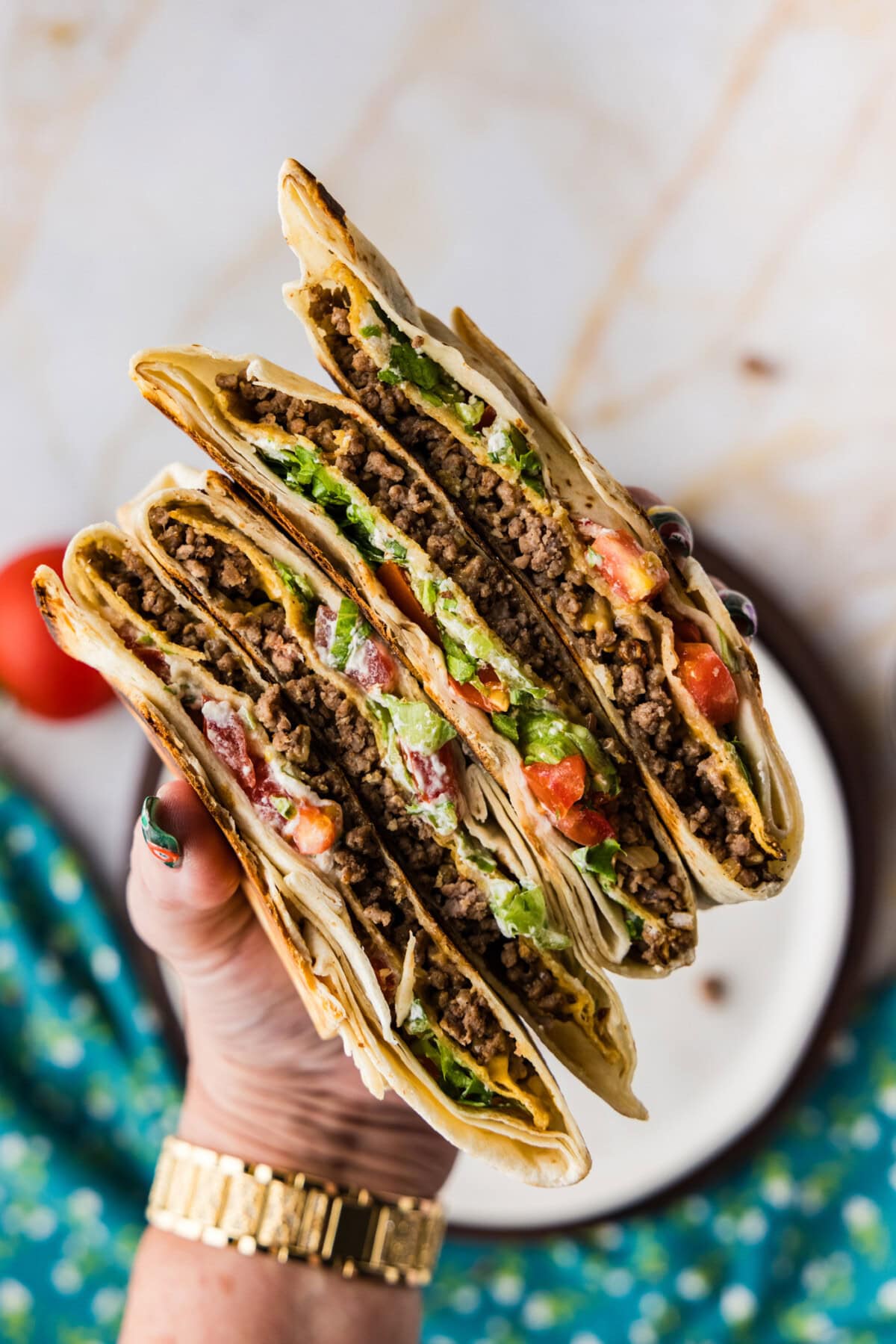 holding sliced Copycat Taco Bell Crunchwrap Supreme