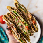 holding sliced Copycat Taco Bell Crunchwrap Supreme
