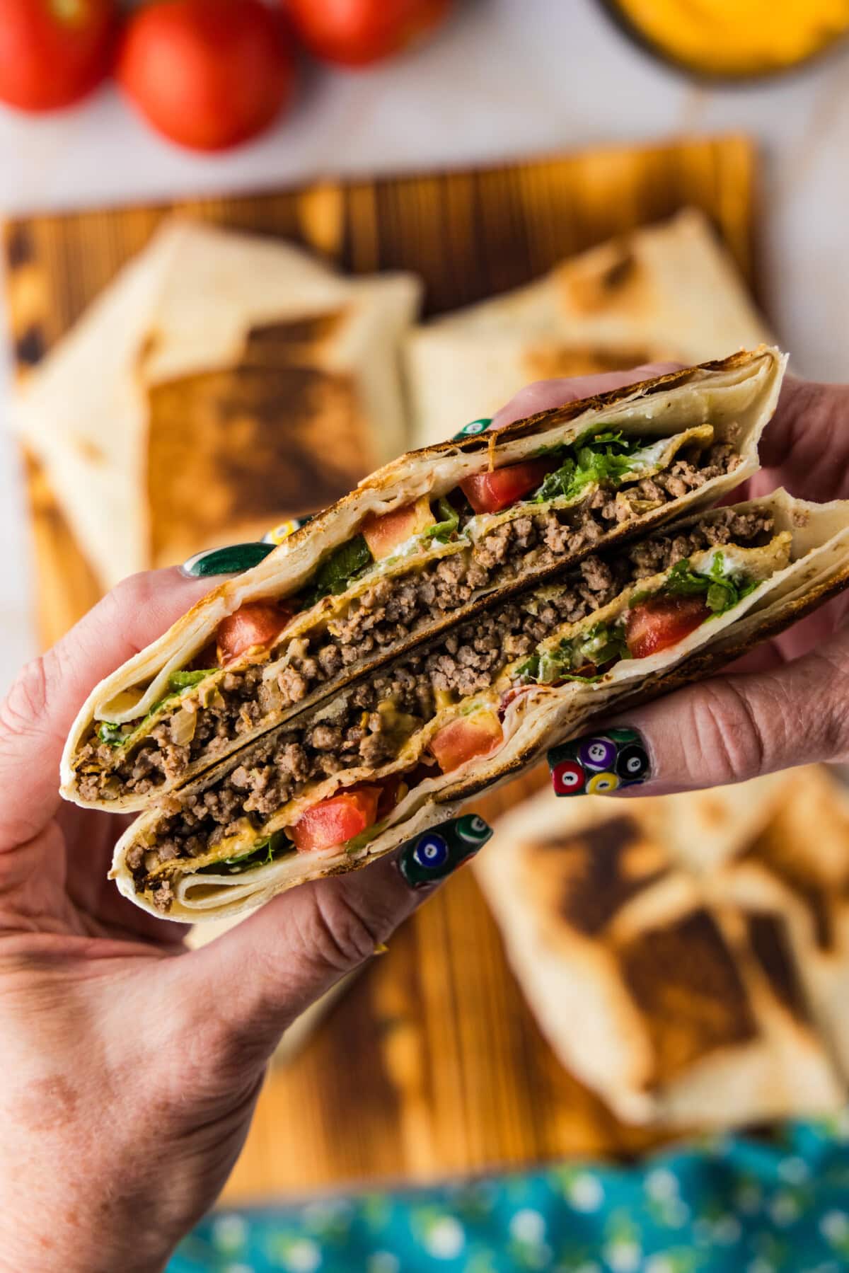 hand holding a cut Copycat Taco Bell Crunchwrap Supreme