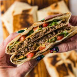 hand holding a cut Copycat Taco Bell Crunchwrap Supreme