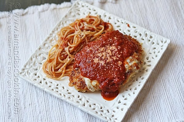 An overhead photo of chicken parmesan on a white decorative plate.