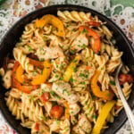 overhead photo of chicken and peppers pasta in black bowl