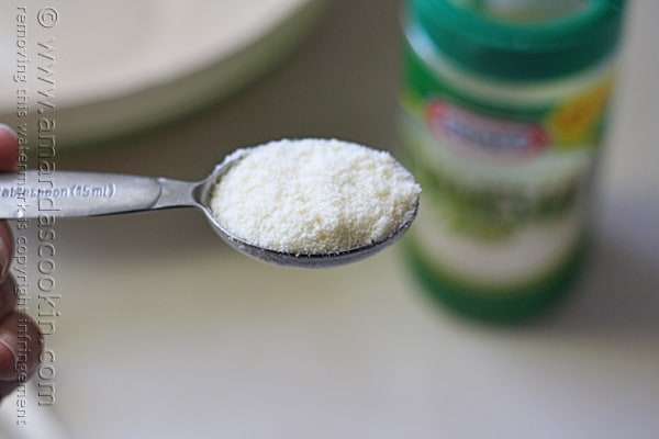 A close up photo of a tablespoon of Parmesan cheese.