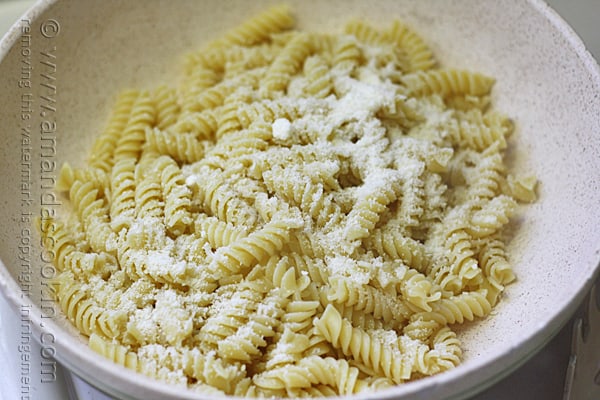 A close up of a bowl filled with Rotini pasta and topped with Parmesan cheese.