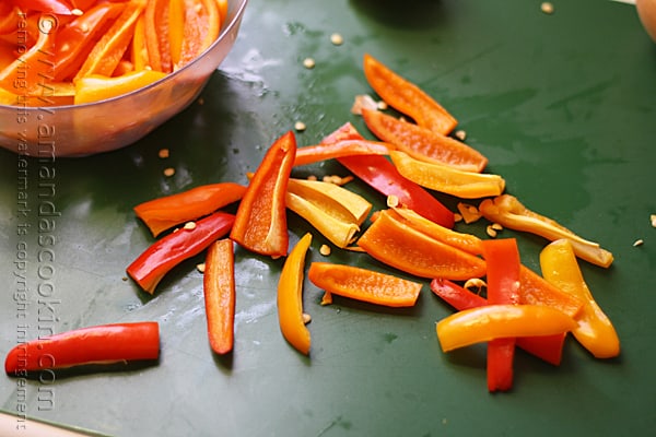 A close up photo of chopped red and orange sweet peppers.