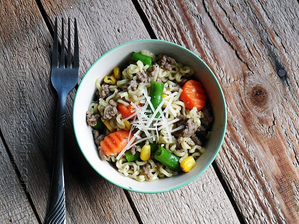 An overhead photo of ramen noodle and beef skillet in a blue and white bowl.