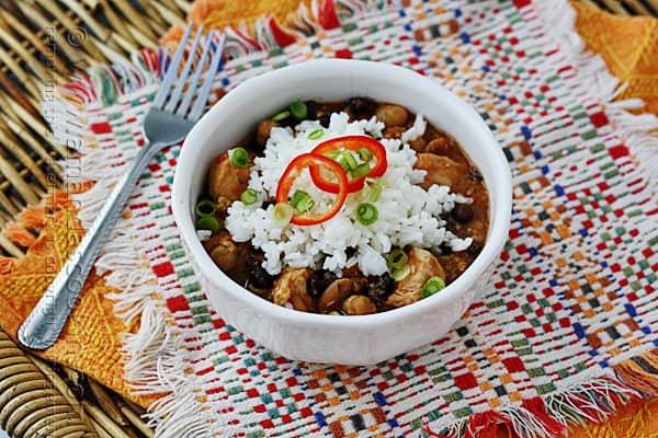 A close up of a white bowl filled with three bean salsa chicken and rice.