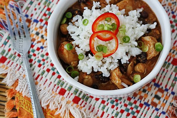 A close up overhead of a white bowl filled with three bean salsa chicken and rice.