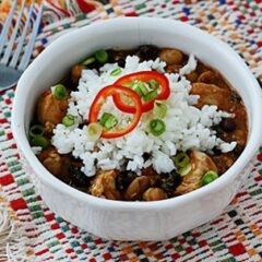 A close up of a white bowl filled with three bean salsa chicken and rice.