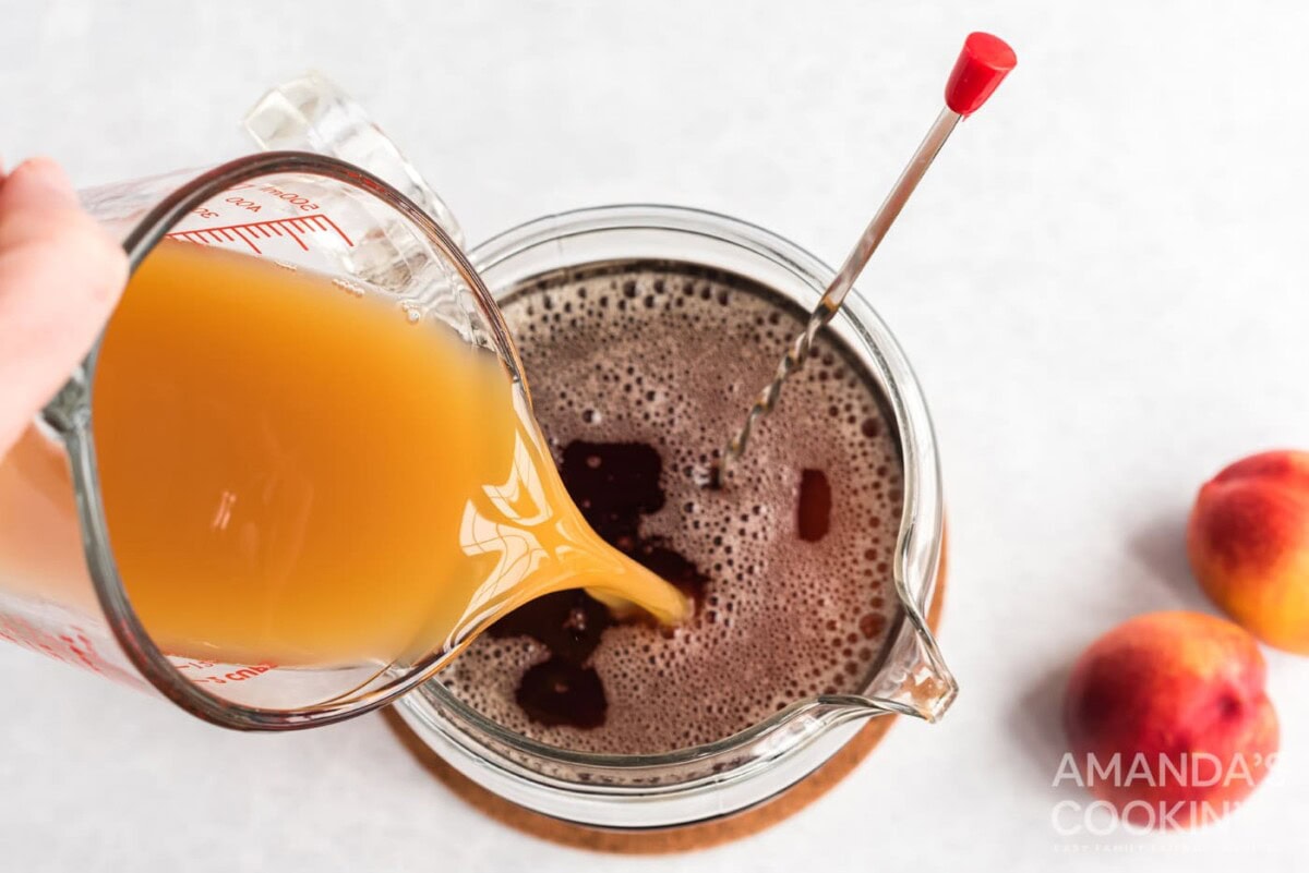 pouring peach nectar into tea