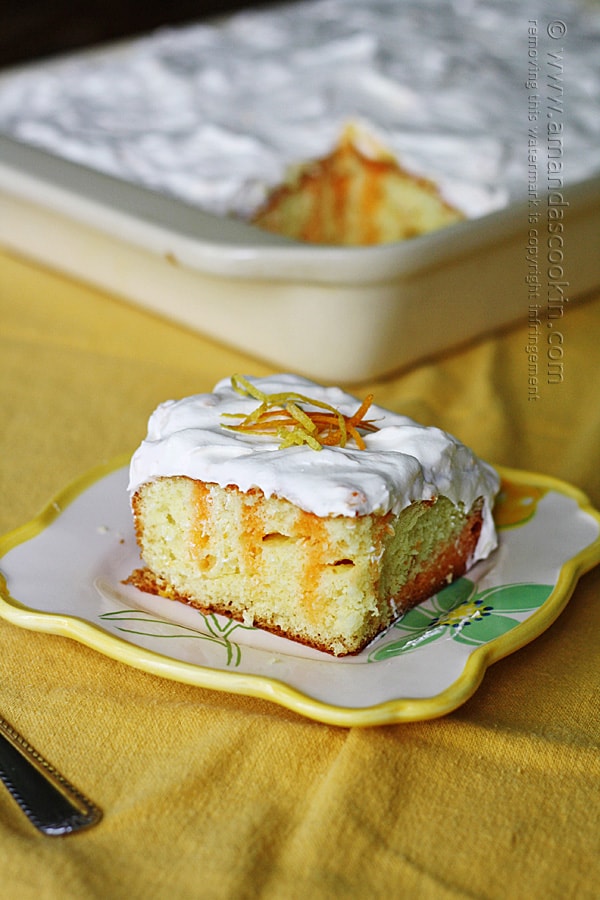 A piece of citrus lover\'s poke cake on a square plate.