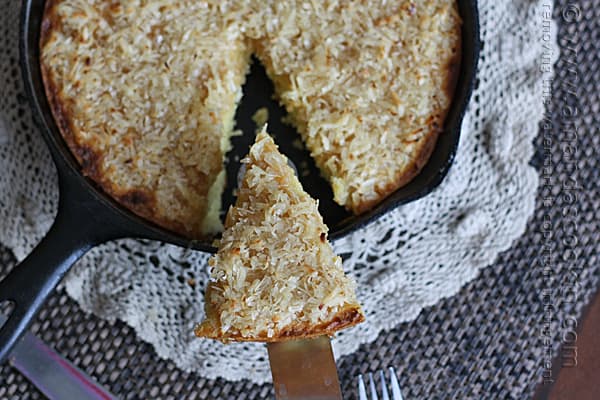 An overhead photo of a lazy daisy cake with a slice being removed.