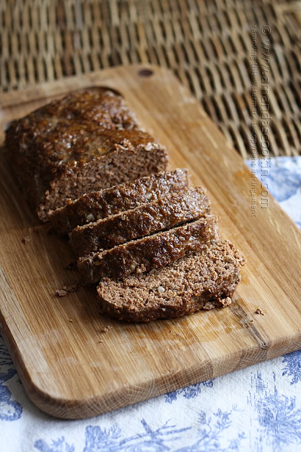 A photo of sliced Quaker oats meatloaf on a wooden cutting board.