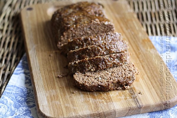 A photo of sliced Quaker oats meatloaf on a wooden cutting board.