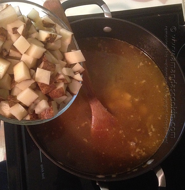 adding potatoes to soup