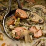 Close up of sausage wild rice soup with mushrooms and celery in a ladle
