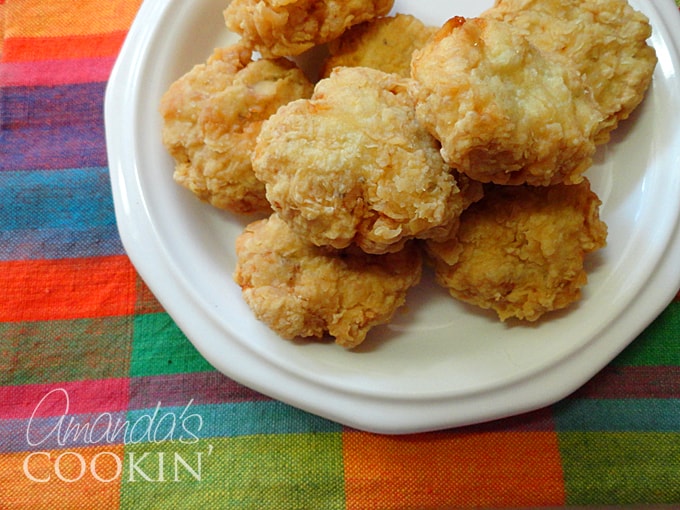 A close up overhead photo of homemade chicken nuggets on a white plate.