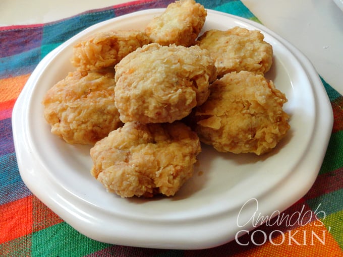 A close up overhead photo of homemade chicken nuggets on a white plate.