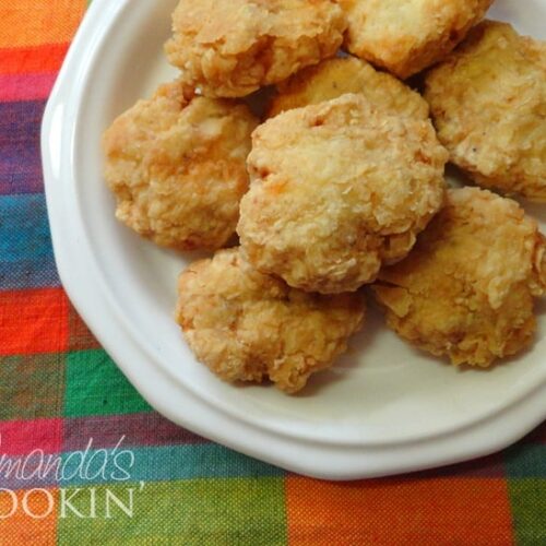 A close up overhead photo of homemade chicken nuggets on a white plate.