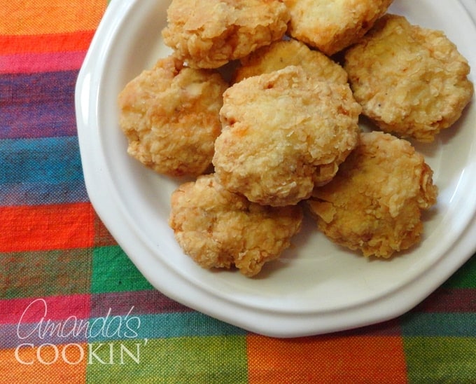 A close up overhead photo of homemade chicken nuggets on a white plate.