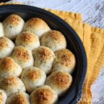 A close up photo of meatball stuffed biscuits in a cake pan.