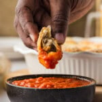 dipping a meatball stuffed biscuit in marinara