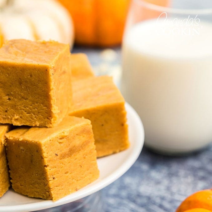 close up of pumpkin fudge squares and glass of milk