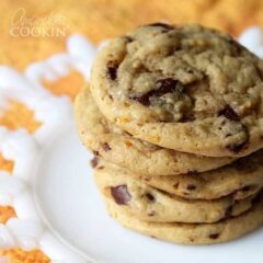 A close up photo a stack of orange chocolate chip cookies.