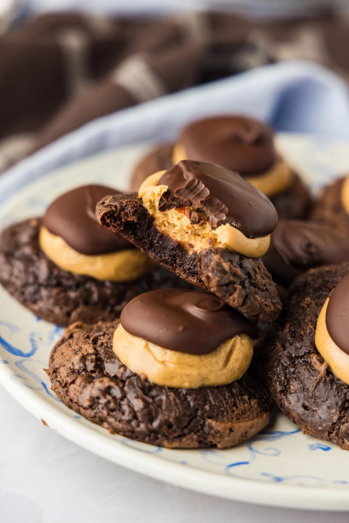close up of a plate of buckeye brownie cookies - one has a bite out of it