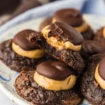 close up of a plate of buckeye brownie cookies - one has a bite out of it