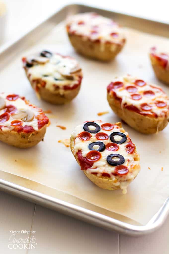 A close up of a baked potato pizzas on a baking sheet.