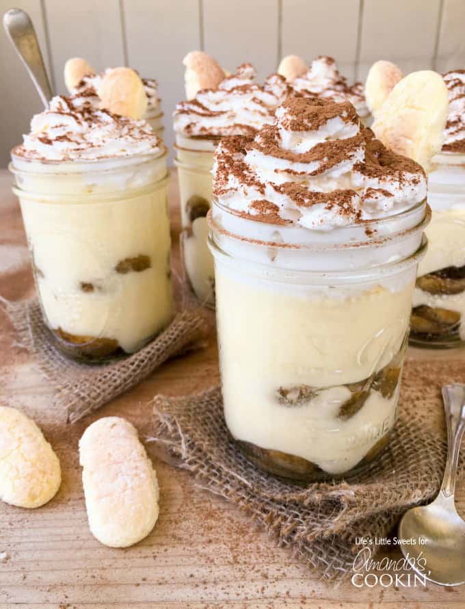 A close up photo of tiramisu trifles in mason jars.