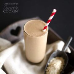 A close up photo of a loaded coffee smoothie served with a red and white straw.