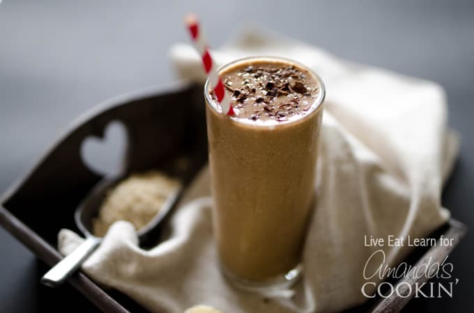 A close up photo of a loaded coffee smoothie served with a red and white straw.