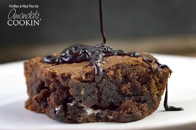 A close up photo of chocolate sauce being drizzled on a peppermint patty brownie.