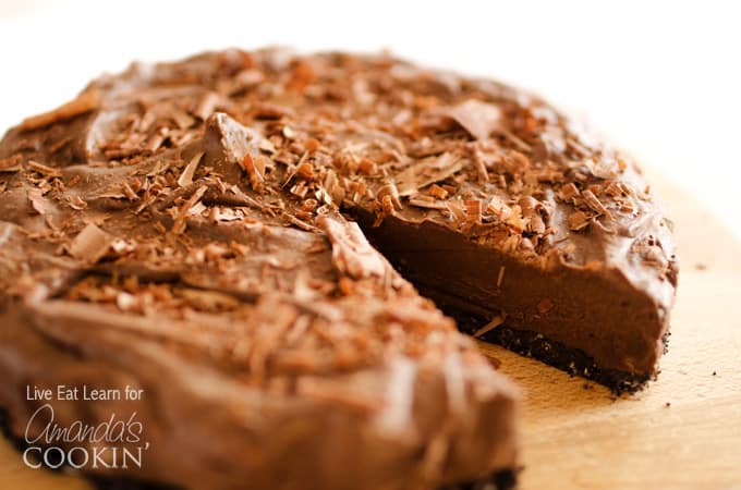 A close up of an avocado chocolate mousse cake with a slice missing.